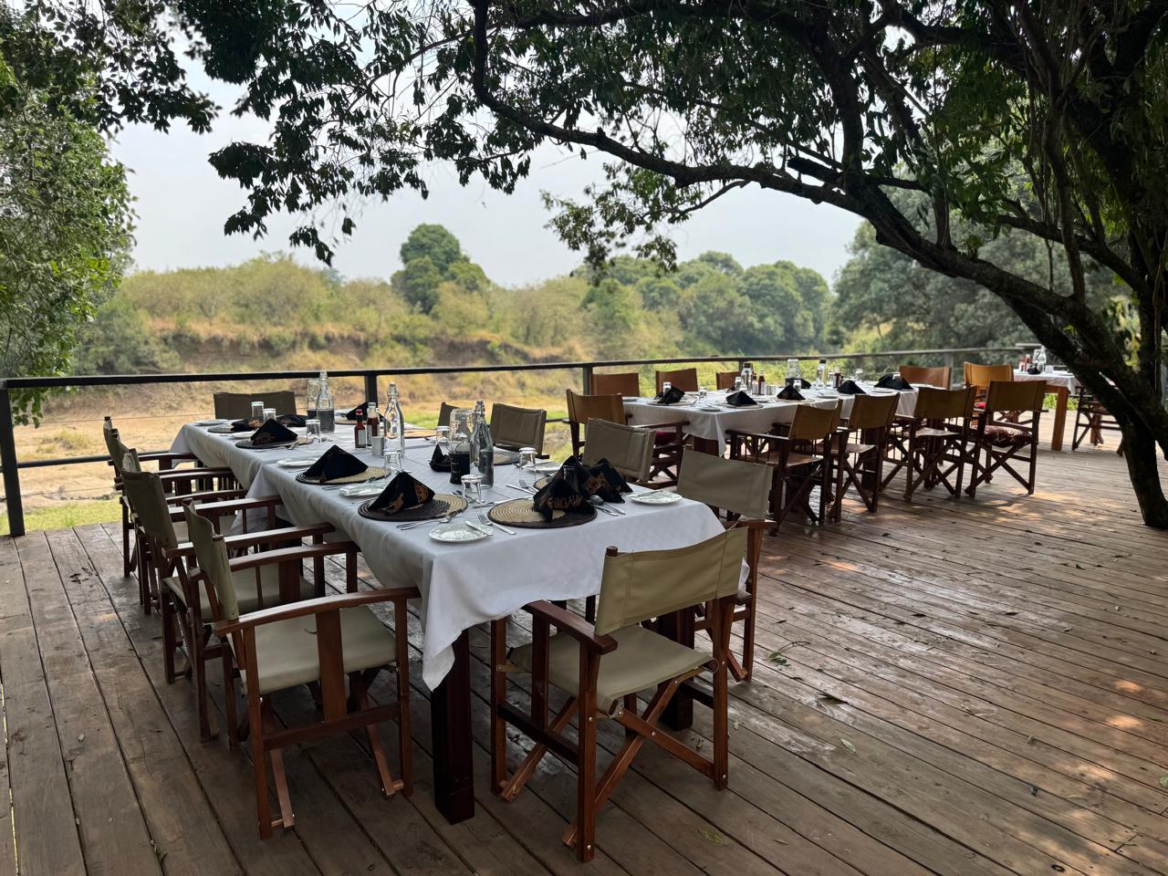 Full group dining table under the trees at Enkakenya — long outdoor setting