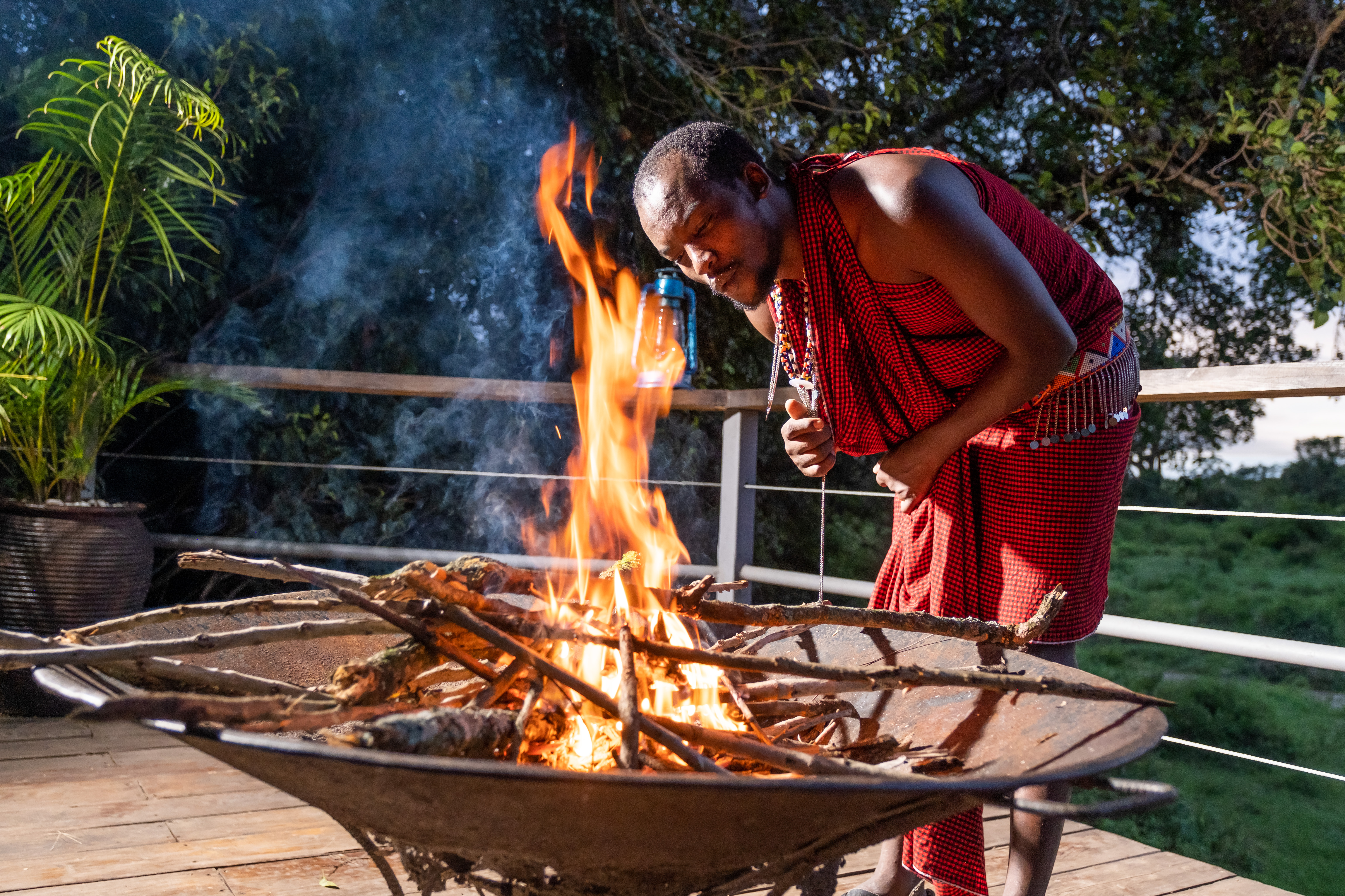 Maasai warrior lighting the evening campfire