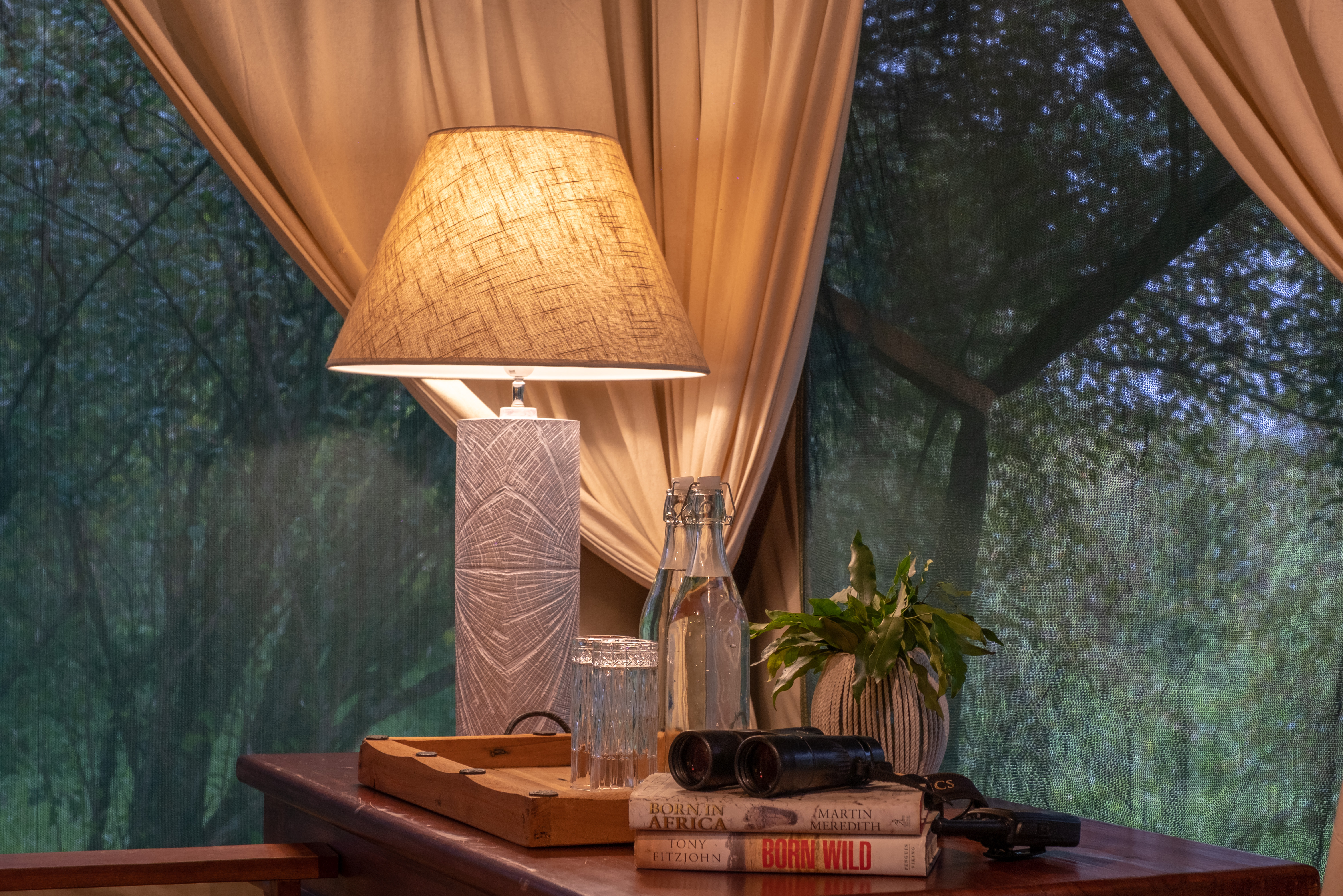 Private tent deck lanterns at dusk facing the river